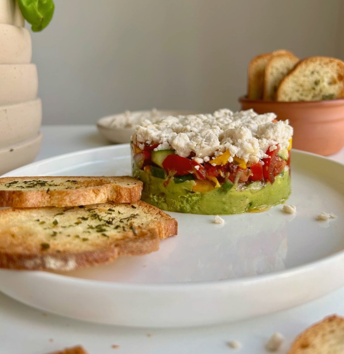 Tartare végétalien coloré avec avocat, tomate, poivron et fromage végétal, parfait pour une entrée saine et savoureuse au printemps.